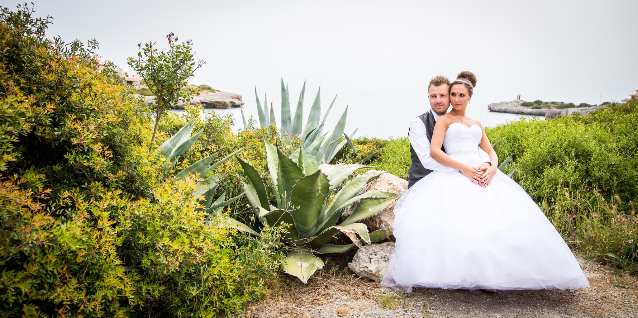 Afterwedding mallorca brautpaar sitzt auf stein